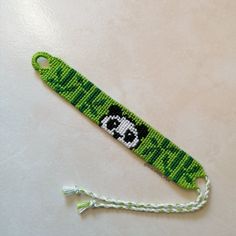 a green beaded key chain with a panda face on it