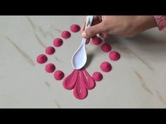 a person holding a spoon with pom - poms on it