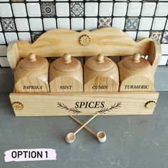 four spice jars in a wooden holder with spoons