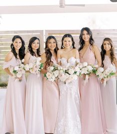 a group of women standing next to each other holding bouquets