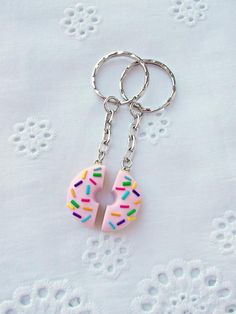 a pink doughnut with sprinkles is on a silver keychain