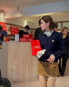 a woman standing in front of a counter holding shopping bags