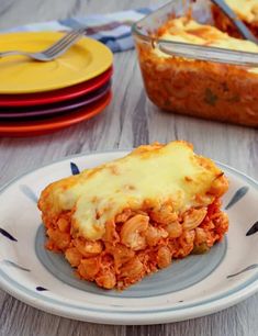 a slice of lasagna on a plate with sauce and cheese in the background