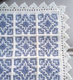 a blue and white crocheted pillow sitting on top of a couch