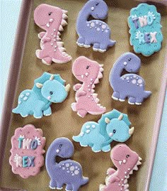 decorated cookies in the shape of dinosaurs on a tray