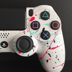 a close up of a video game controller with paint splattered on the side