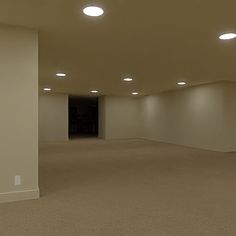 an empty room with several lights on the ceiling and carpeted floor in front of it