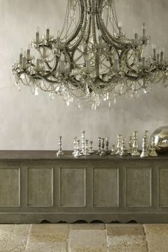 a chandelier hanging from the ceiling over a table with chess pieces on it