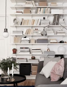 a living room filled with lots of furniture and bookshelves on top of it