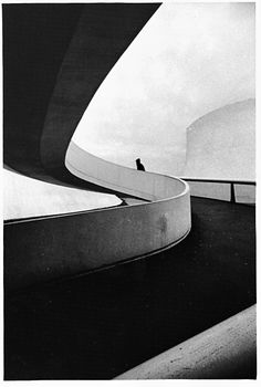 a skateboarder is doing a trick on the edge of a concrete ramp in black and white