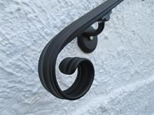 a close up of a black metal handle on a white wall