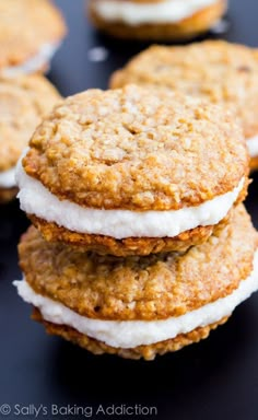 several cookies with white frosting and graham crackers on a black surface, ready to be eaten