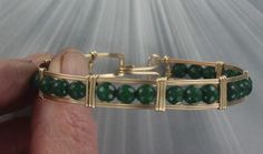 ELEGANT HIGH FASHION   GENUINE   EMERALD GEMSTONE BANGLE BRACELET IN  14kt Rolled Gold HANDCRAFTED IN 14kt rolled gold   IN A UNIQUELY DESIGNED SETTING The stones are  8  mm  UNIQUE HANDCRAFTED PIECE THAT WILL GET YOU NOTICED! LIGHTWEIGHT AND EASY TO WEAR SIZE ----- SIZE 6 TO 8 BRACELET IS 1/2 AN INCH WIDE  iTS COMFORTABLE HEAVY DUTY HOOK AND CATCH MAKES IT EASY TO TAKE ON AND OFF AN EYE CATCHING PIECE! WEAR IT CASUAL OR FORMAL THE GEMSTONES ARE FACETED 6MM EMERALD GEMSTONES OUR GEMSTONES ARE AAA HIGH GRADE  EMERALD  ABOUT MY JEWELRY This is wire sculpted Jewelry all made by hand. It is created wire by wire with the best metals and material in the business.  Such as Sterling Silver, and precious stones, and 14kt rolled gold. Each item is a small work of art and has been made using small st Elegant Green Hand Wrapped Bracelets, Elegant High Fashion, Sculpted Jewelry, Gemstone Bangle Bracelets, Gemstone Bangle, Bracelet Cuff, Emerald Gemstone, Gemstone Bracelet, Silver Wire