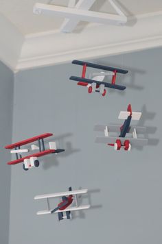 four toy airplanes are hanging from the ceiling