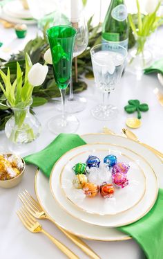 a table set for st patrick's day with green napkins and goldware