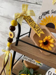 some sunflowers are sitting on top of a wooden stand with yellow ribbon around them