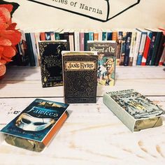 several books are sitting on a table with flowers in front of them and a sign that reads, the stories of narnia