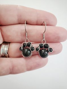 "These adorable little paw prints are made with 4mm and 8mm gemstone beads. They are perfect for animal lovers! Made with 100% stainless steel 24 gauge wire and earring hooks. They hang approximately 0.75\" down from earring hook.  The earrings will come on an earring card with silicone earring backs, and packaged in a charming box, perfect for easy gifting! Amethyst is a transparent to translucent stone that has a lavender to reddish violet hue.  It is found in many locations around the world, Wire Wrapped Paw Print, Kitten Earrings, Wire Creations, Paw Jewelry, Paw Print Earrings, Lover Jewelry, Dog Earrings, Earring Card, Plastic Earrings