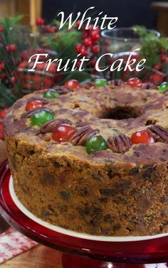 a cake on a red plate with white frosting and fruit in the top layer