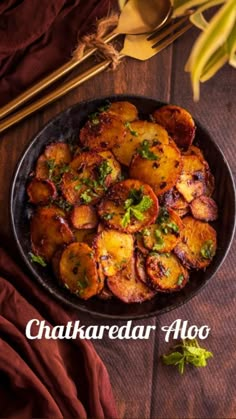 a plate full of potatoes on top of a wooden table with chopsticks next to it