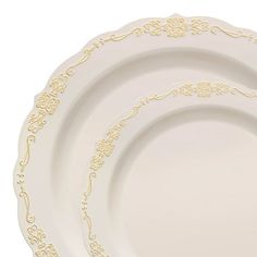 three white plates with gold designs on them