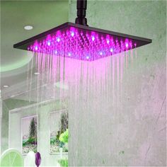 a shower head with purple lights hanging from it's side