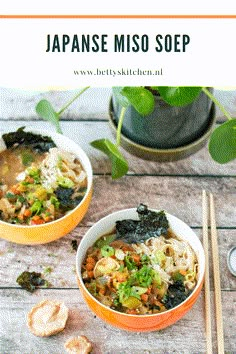 two bowls of japanese miso soup with chopsticks next to it on a wooden table