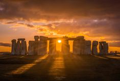 the sun is setting over stonehenge in england