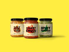 three jars of spicy seasoning on a yellow background