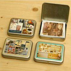 four tins with pictures in them sitting on a wooden table next to each other