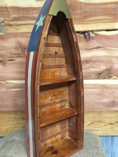 a wooden boat shaped book shelf with an american flag painted on it