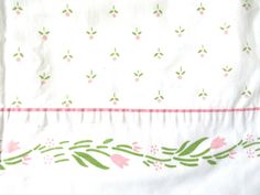 a white sheet with pink and green flowers on it