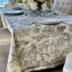 a dining room table covered with a black and white toiler print linens