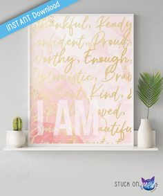 a pink and gold art print with the word i am in cursive writing