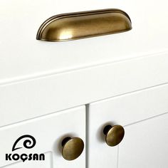 a white cabinet with brass handles and knobs