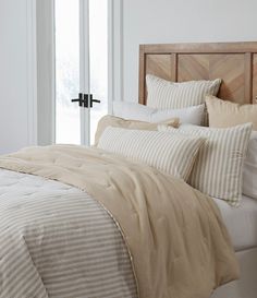 a bed with beige and white striped comforters