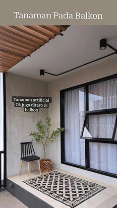 a black chair sitting on top of a white floor next to a wooden window sill