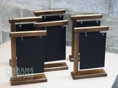 there are three small blackboards on the wooden stand next to each other and one is empty