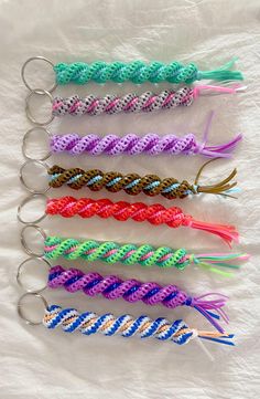 five different colored braided key chains on a white sheet