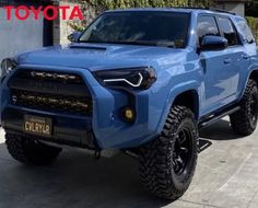 a blue toyota truck parked in front of a building