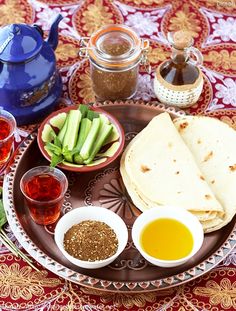 an assortment of food on a plate with sauces and condiments around it