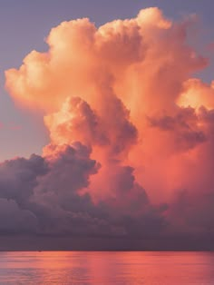 the sky is pink and purple as it reflects in the water with clouds above them