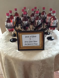 a table topped with lots of bottles of liquor on top of a white table cloth