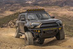 a gray truck driving down a dirt road