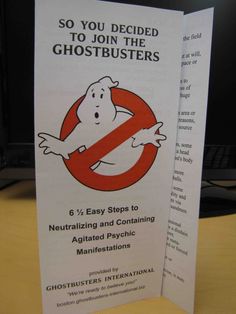 a ghostbuster's sign on a table in front of a computer screen