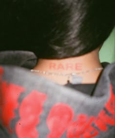 the back of a woman's neck with a tattoo on it that reads rare