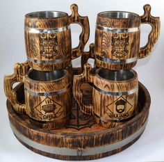 a set of wooden beer mugs sitting on top of a barrel shaped serving tray