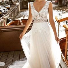 a woman in a wedding dress standing on a boat