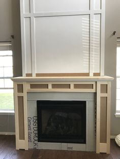 an empty fireplace in a living room with white paneling