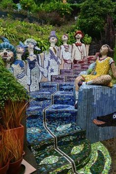 a group of people sitting on top of steps made out of mosaic tiles and plants